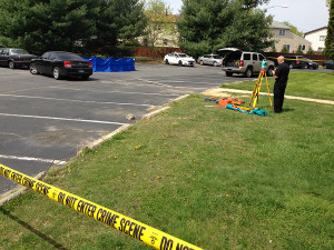 Blue tarp covered body of homicide victim in parking lot at Pine Grove Apartments in Dover.