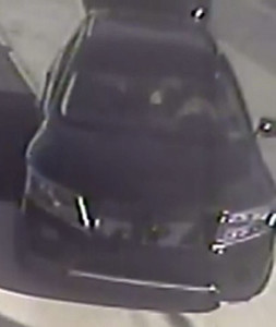 Police released surveillance image of SUV with broken grill fleeing scene of gas station robbery and shooting.