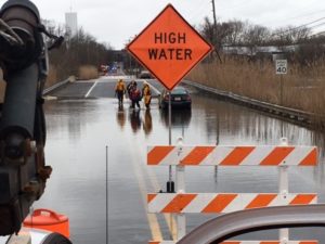 Firefighters escort women to safety after their cars became stranded in flooding from Nonesuch Creek on Airport Road. (Photo: Delaware Free News)